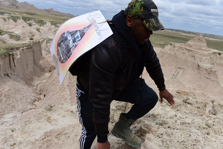 Airman 1st Class Alexander Robinson, aerospace ground equipment apprentice assigned to the 28th Maintenance Squadron, carries a Holocaust Remembrance Week banner through the Badlands National Park, S.D., April 28, 2017. This is the second year the Ellsworth Diversity Council sponsored Holocaust Remembrance Week which took place April 24-28, 2017. (U.S. Air Force photo by Airman 1st Class Randahl J. Jenson)