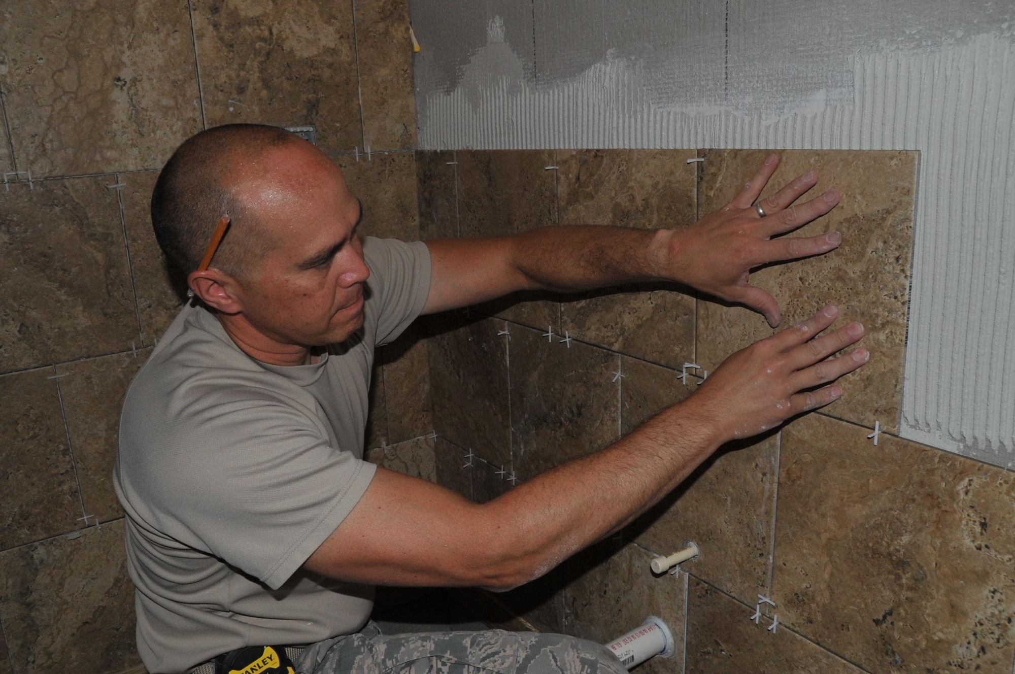 Senior Airman Martin Sturgeon, 919th Special Operations Civil Engineering Squadron structural specialist, replaces the tiles in the newly rebuilt bathroom, May 2, 2017 in the 53rd Weather Reconnaissance Squadron, Detachment 1 building located at Henry E. Rohlsen Airport in St. Croix, U.S. Virgin Islands. The repairs and improvements were completed by Members of the 919th Special Operations Civil Engineering Squadron during the annual "roll-out" for the upcoming hurricane season, April 30-May 10. (U.S. Air Force Photo//Master Sgt. Jessica Kendziorek)