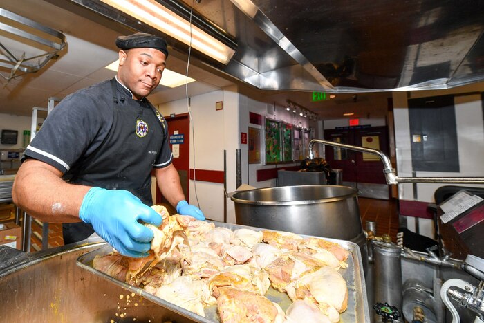 Navy Petty Officer 2nd Class Kevin Miller removes seasoned chicken from the kettle while preparing lunch at Naval Base Kitsap, Wash., May 2, 2017. Miller is a culinary specialist. Navy photo by Petty Officer 3rd Class Charles D. Gaddis IV