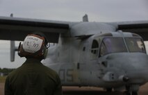 A Marine with Marine Tiltrotor Squadron (VMM) 268 guides an MV-22B Osprey into position after the aircraft landed at Royal Australian Air Force Base Darwin, Australia, April 28, 2017. Four MV-22B Ospreys arrived to begin a deployment to Marine Rotational Force-Darwin 17.2. VMM-268, also known as the “Red Dragons,” are the first to make a trans-Pacific flight with the MV-22B Osprey. (U.S. Marine Corps photo by Lance Cpl. Damion Hatch)