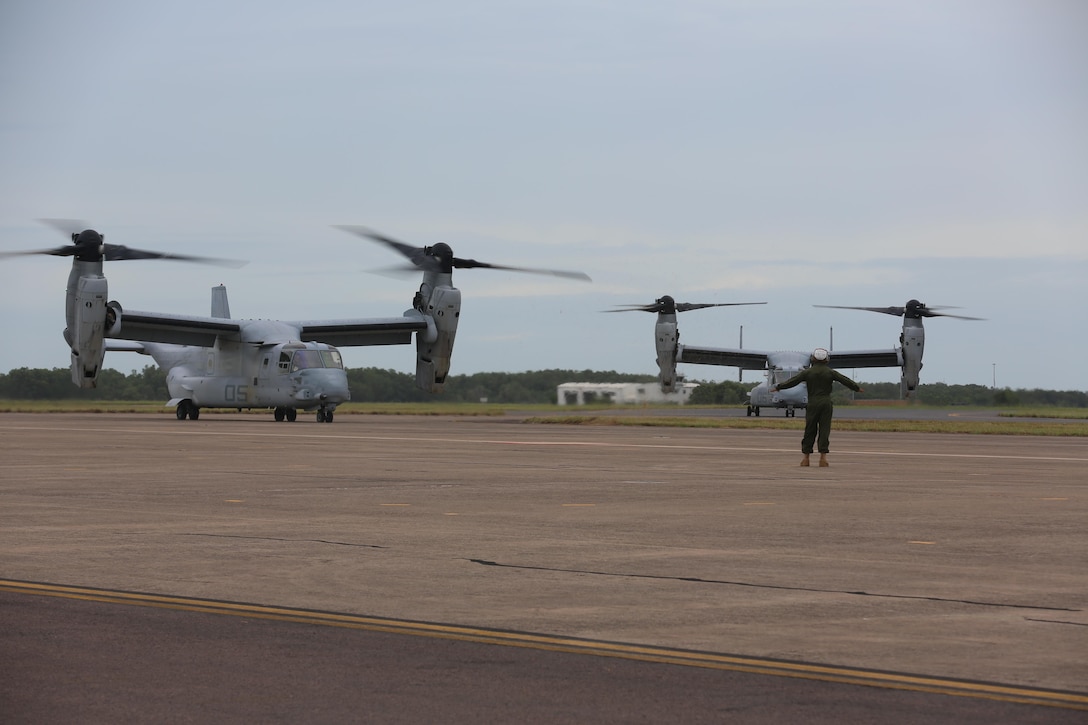 A Marine with Marine Tiltrotor Squadron (VMM) 268 guides an MV-22B Osprey into position after the aircraft landed at Royal Australian Air Force Base Darwin, Australia, April 28, 2017. Four MV-22B Ospreys arrived to begin a deployment to Marine Rotational Force-Darwin 17.2. The Ospreys flew approximately 6,000 miles across the Pacific in 21-hours of flight time. (U.S. Marine Corps photo by Lance Cpl. Damion Hatch)