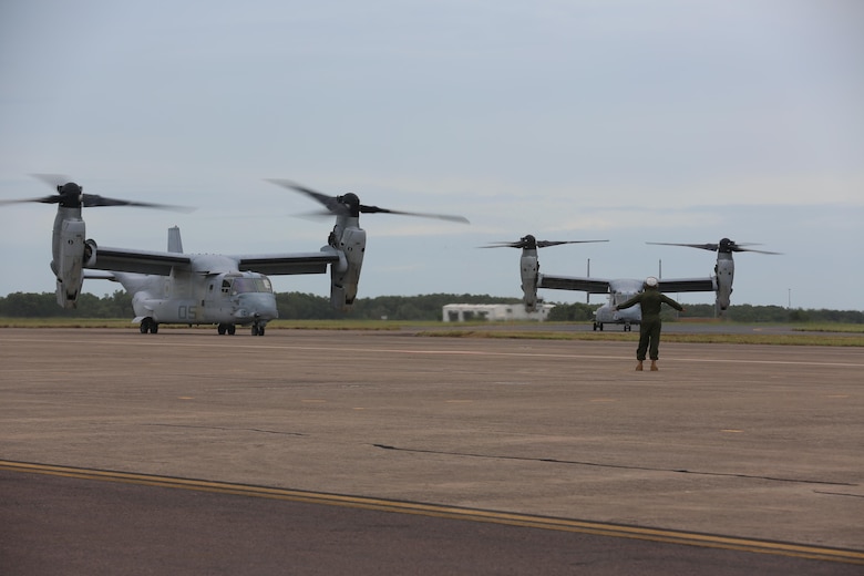 A Marine with Marine Tiltrotor Squadron (VMM) 268 guides an MV-22B Osprey into position after the aircraft landed at Royal Australian Air Force Base Darwin, Australia, April 28, 2017. Four MV-22B Ospreys arrived to begin a deployment to Marine Rotational Force-Darwin 17.2. The Ospreys flew approximately 6,000 miles across the Pacific in 21-hours of flight time. (U.S. Marine Corps photo by Lance Cpl. Damion Hatch)