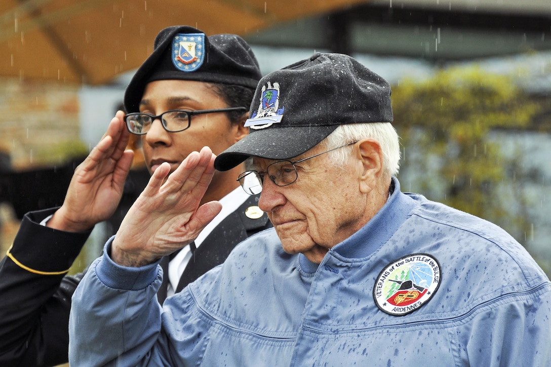 Retired Army Col. Douglas Dillard, right, and Army Staff Sgt. Natasha Love salute during a ceremony marking the 72nd anniversary of the capture of Obersalzberg, Germany, and the last major military operation of World War II in Garmisch, Germany, May 5, 2017. Dillard, a 91-year-old World War II veteran who fought in the Battle of the Bulge, spoke during the event. DoD photo by James E. Brooks