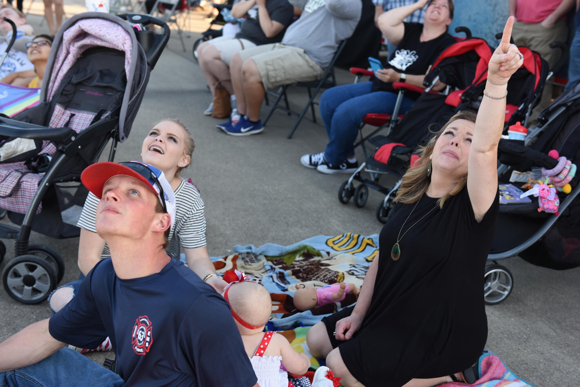Spectators react to the Canadian Skyhawks as the parachutists jump out of a C-17 Globemaster during the 2017 Defenders of Liberty Air Show at Barksdale Air Force Base, La., May 5, 2017. The inherent flexibility of the C-17 allows it to fulfill the worldwide air mobility requirements of the U.S. through rapid strategic delivery of troops and cargo. (U.S. Air Force photo/Senior Airman Luke Hill)