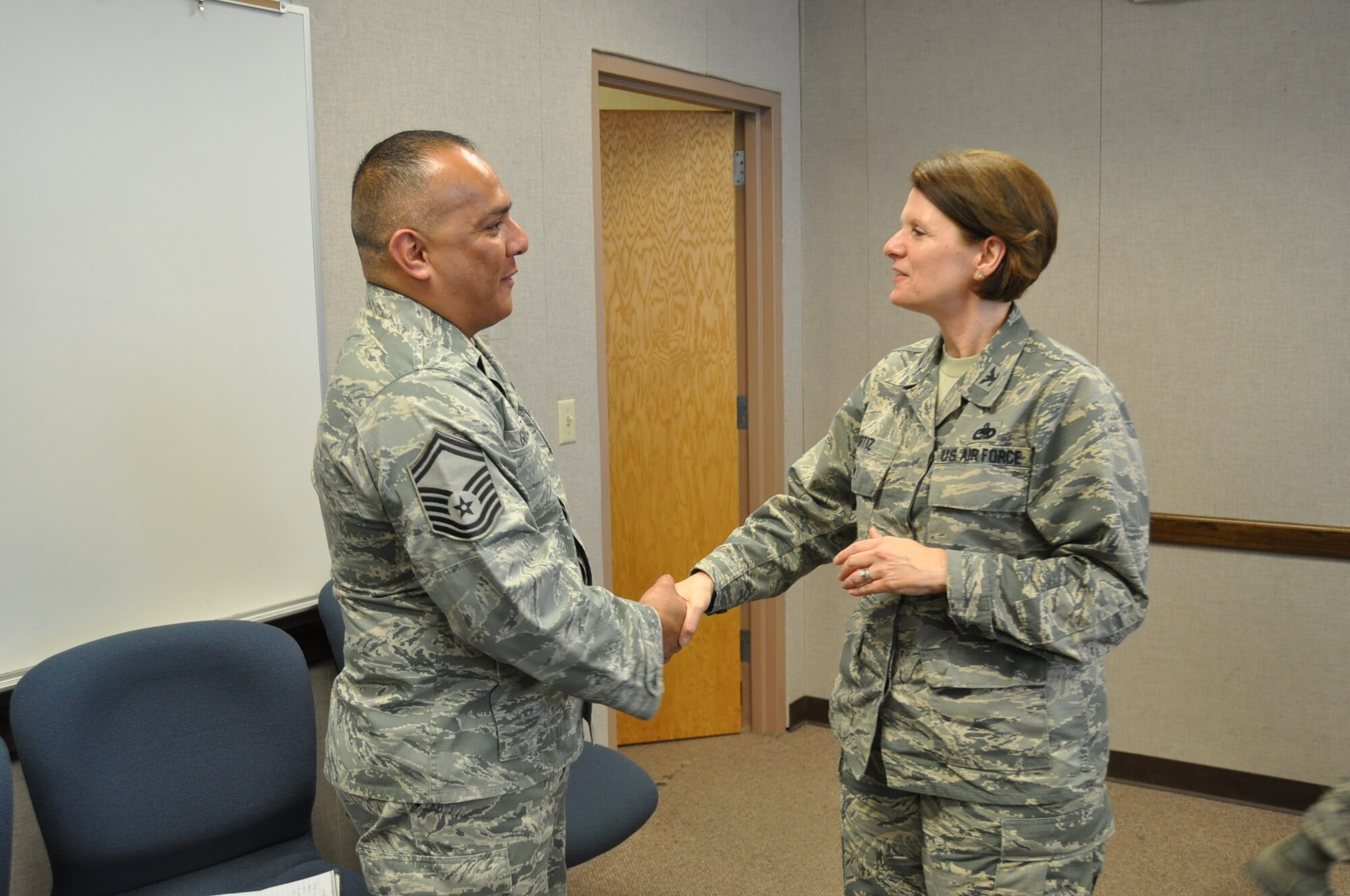 Col. Barbara Ortiz, Air Force Reserve Command Logistics Readiness Division chief, presents a coin to Senior Master Sgt. Joe Gonzalez, 26th Aerial Port Squadron Operations superintendent, for the database he helped create which provides senior leaders comprehensive reports from multiple platforms. (U.S. Air Force photo/Senior Airman Bryan Swink)