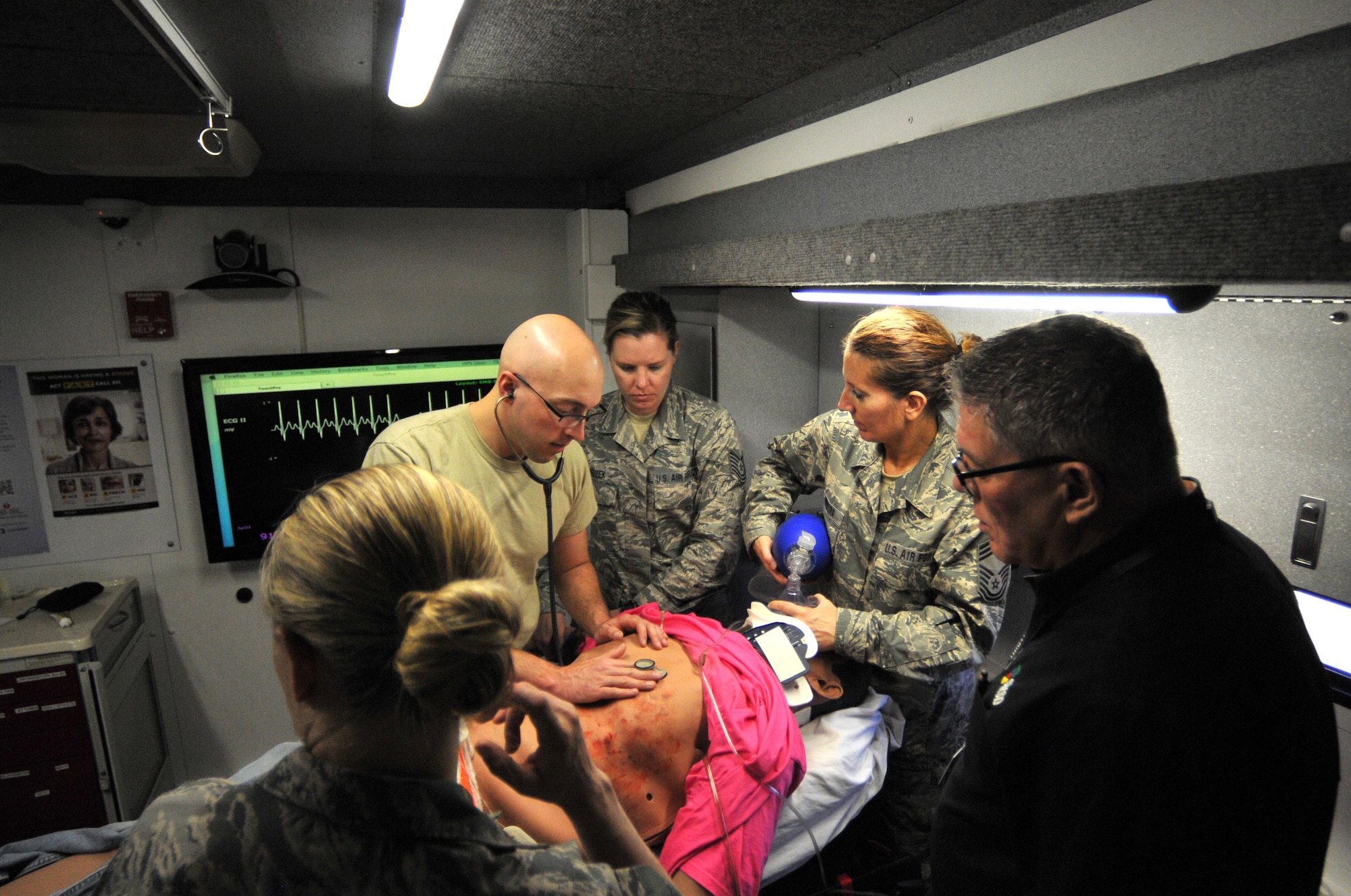 Branden Marienau, Simulation in Motion South Dakota (SIMSD) education coordinator, shared a few tips with a team of medics from the 114th Medical Group during a simulated medical emergency in the SIMSD Vehicle on Joe Foss Field May 6, 2017.  The Vehicle was visiting Jose Foss Field in order to provide realistic trauma emergency simulations to the medics from the 114th Medical Group.  (U.S. Air National Guard photo by Master Sgt. Christopher Stewart/Released)