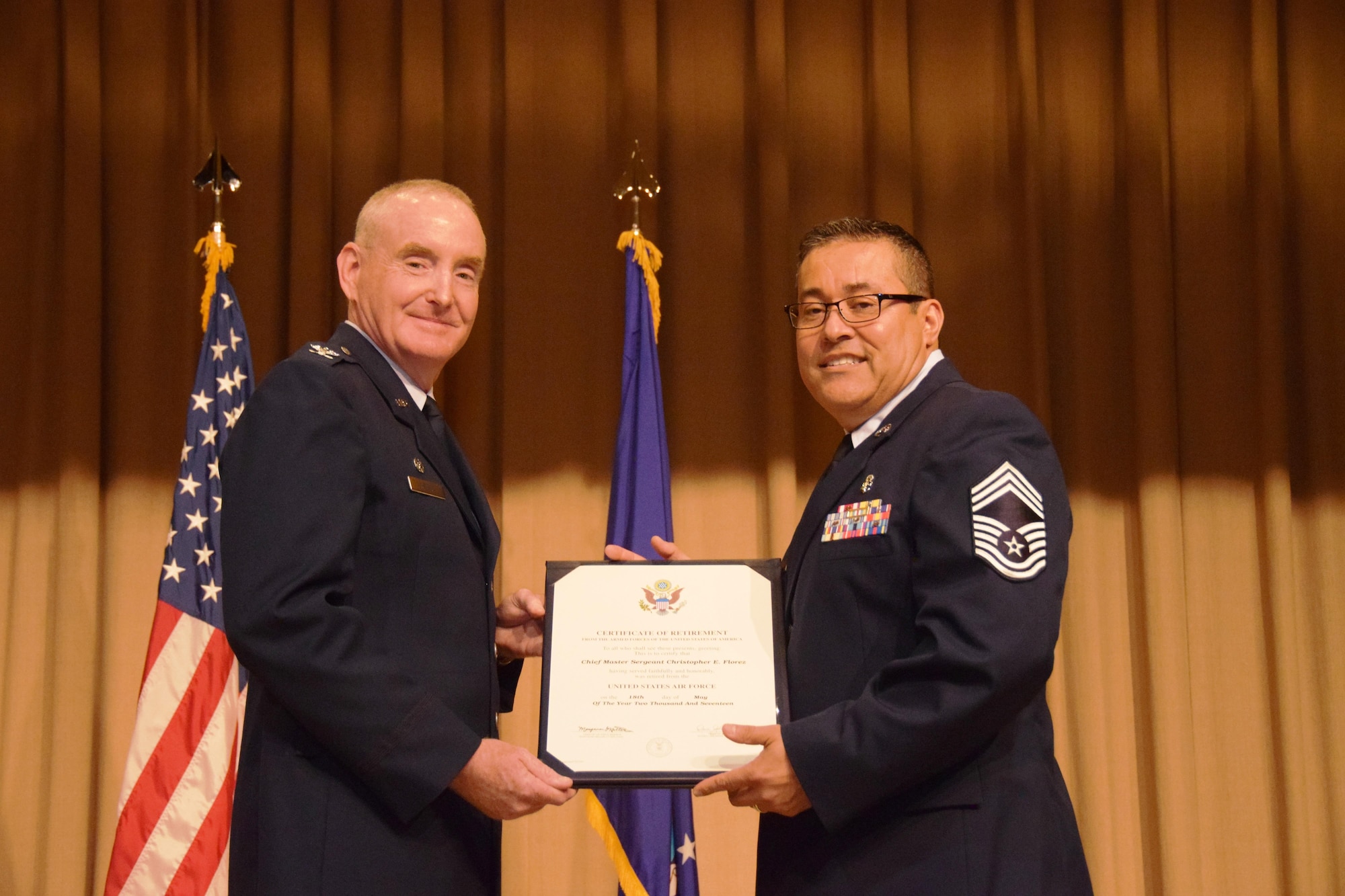 Col.  Michael D. Nelson, 433rd Medical Squadron commander presents the official retirement certificate to Chief Master Sgt. Christopher E. Florez, May 7, 2017 on Joint Base San Antonio-Lackland, Texas.  (U.S. Air Force photo by Tech. Sgt. Carlos J. Trevino)