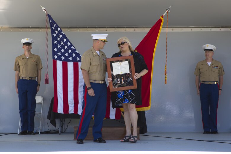 Maj. Chris Cotton, commanding officer of Recruiting Station Montgomery, give the Navy and Marine Corps Medal to Lorri Wyatt, wife of Staff Sgt. David Wyatt, at Ross’s Landing in Chattanooga, Tenn., May 7, 2017. Cotton is the former Inspector-Instructor for Battery M, 3rd Battalion, 14th Marine Regiment, 4th Marine Division, Marine Forces Reserve, the unit that Wyatt was assigned to. (U.S. Marine Corps Photo by Lance Cpl. Niles Lee/Released)