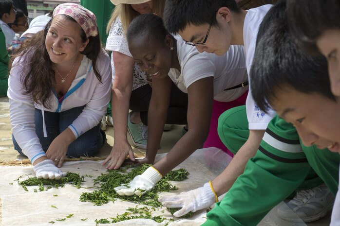 Stefanie Hansen and Tanesha Wallen, Marine Corps Air Station Iwakuni residents, press and roll green tea leaves with Hirose-Iwakuni High School students during a Cultural Adaption Program tea harvesting event in Iwakuni City, May 2, 2017. The Cultural Adaptation Program gave station residents the opportunity to experience the Japanese culture alongside elementary and high school students, nursing home residents and other Japanese locals. (U.S. Marine Corps photo by Lance Cpl. Carlos Jimenez)