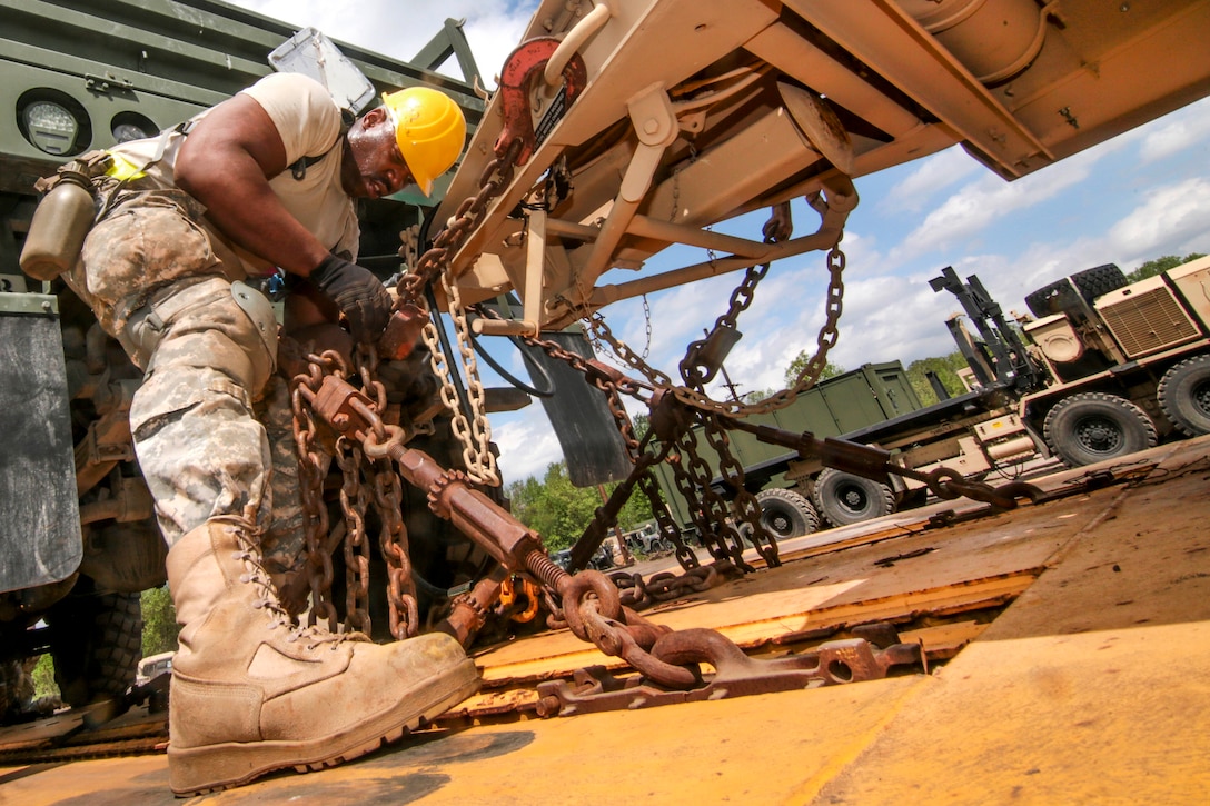 New Jersey Army National Guard Sgt. Dayo Matti tightens chains securing a vehicle onto a rail car in Morrisville, Pa., May 2, 2017. Matti is assigned to the New Jersey Army National Guard’s 102nd Cavalry. Air National Guard photo by Master Sgt. Matt Hecht