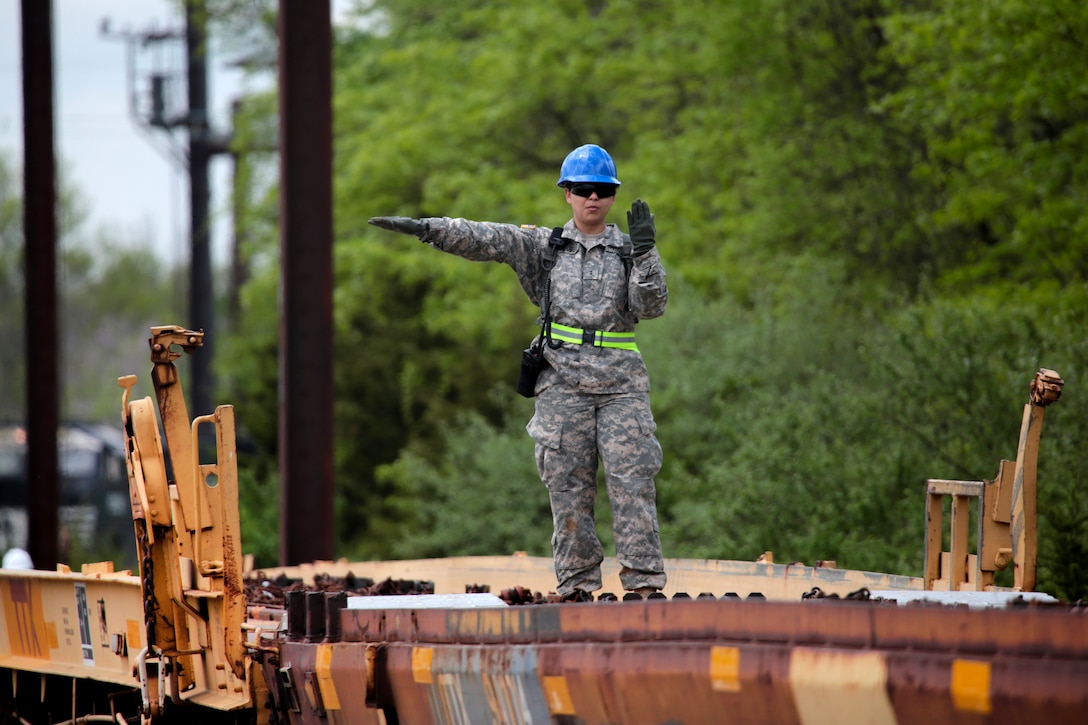 A New Jersey Arm National Guardsman uses hand signals to direct a vehicle onto a rail car at Morrisville Yard, Pa., May 2, 2017. Air National Guard photo by Master Sgt. Matt Hecht