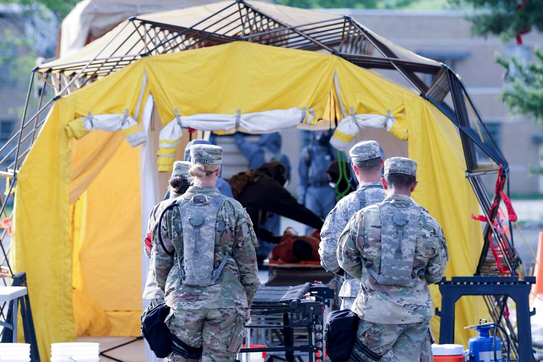 Spc. Megan Rowley and Spc.  Kristopher Fernando medics assigned to the 602nd Area Support Medical Company located at Fort Bragg, N.C., wait for a simulated victim to complete the decontamination process for medical assessment April 29, 2017, as a part of Guardian Response at Muscatatuck Urban Training Center, Ind. Exercise Guardian Response is a multi-component training exercise run by the U.S. Army Reserve designed to validate more than 4,000 service members in Defense Support of Civil Authorities in the event of a Chemical, Biological, Radiological and Nuclear catastrophe. This year's exercise simulated an improvised nuclear device explosion with a source region electromagnetic pulse out to more than four miles. The 84th Training Command hosted the exercise, and the 78th Training Division, headquartered in Joint Base McGuire-Dix-Lakehurst, New Jersey, conducted the training. (U.S. Army Reserve Photo by Staff Sgt. Brad Ruffin, 206th Broadcast Operations Detachment)