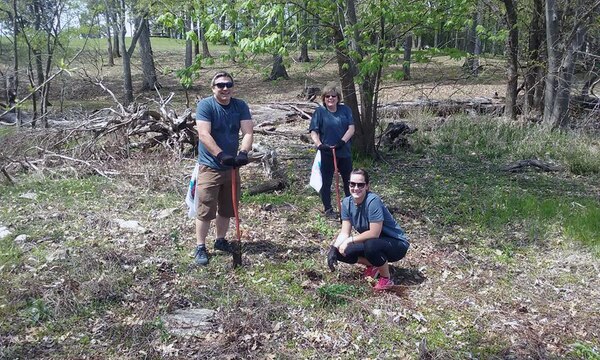 Paul Handley, Jess Brickey (kneeling) and Barbara Woehnker, all volunteers from VF Imagewear, Inc., plant trees in an open area during a lake cleanup in the Cook Recreation Area at J. Percy Priest Lake on April 13, 2017.  