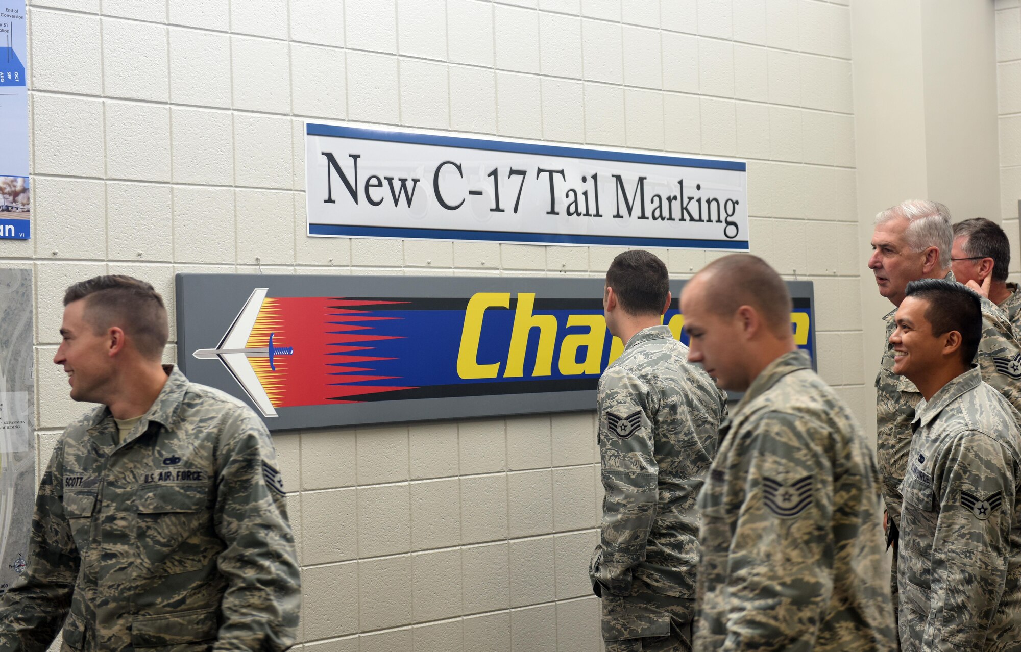 Members of the North Carolina Air National Guard (NCANG) browse the information boards and review the newly unveiled C-17 Globemaster III aircraft tail flash in the dining facility at the NCANG Base, Charlotte Douglas International Airport, May 6, 2017. The tail flash is an integral part of establishing the brand of the NCANG. Every detail from the colors, to the length of the sabre, and the bold print symbolize the importance of new mission that will be carried out by the airmen and C-17 Globemaster III aircraft. (U.S. Air National Guard photo by Staff. Sgt. Laura J. Montgomery)