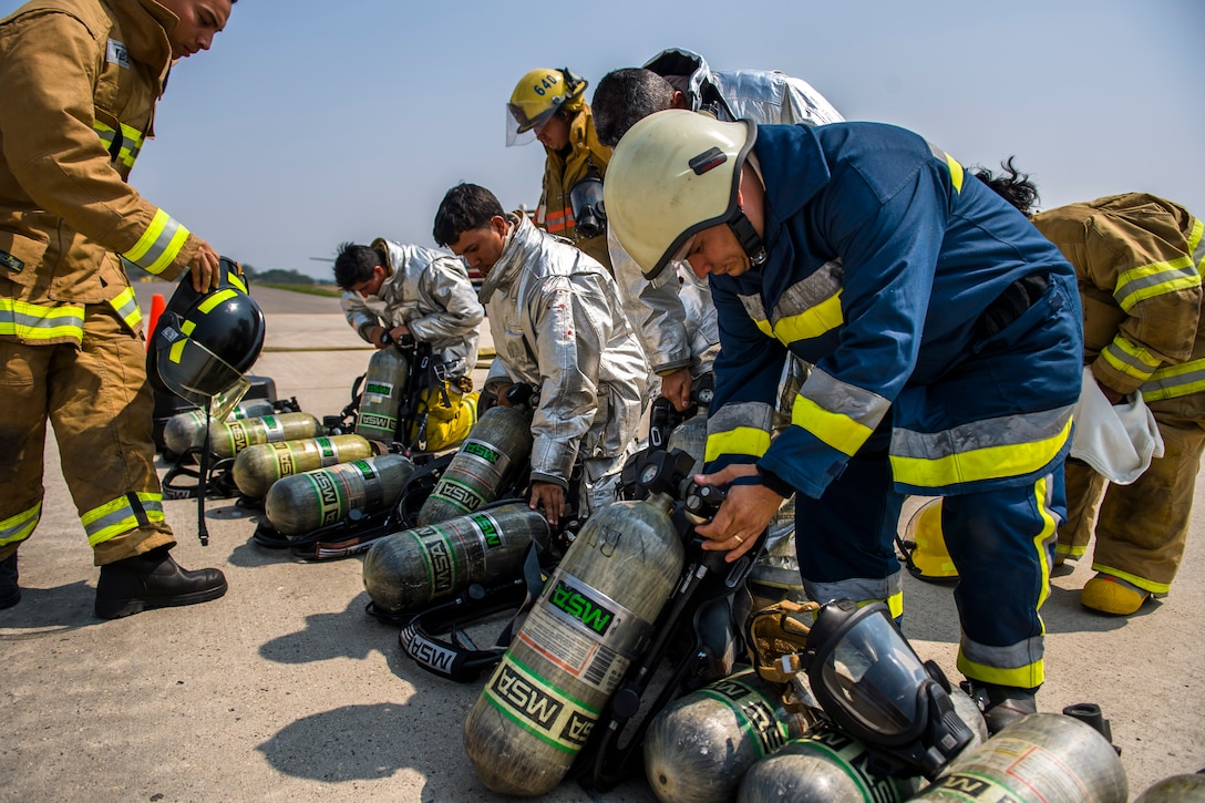 Firefighters from Central America grab their protective gear prior to a live fire exercise about Central America Sharing Mutual Operational and Experience at Joint Task Force – Bravo, Apr. 26, 2017. CENTAM SMOKE is a biannual exercise hosted by Joint Task Force – Bravo with 35 participants from across the 7 Central America nations that includes safety, personal protective equipment, apparatus familiarization, fire hose applications, structural/helicopter live fire evolutions, medical training, vehicle extrication, and aircraft (UH–60/CH–47) egress familiarization, Apr. 24-28, 2017. (U.S. Air National Guard photo by Master Sgt. Scott Thompson/released)