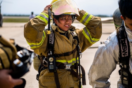 A firefighter from Central America puts on her protective gear prior to a live fire exercise about Central America Sharing Mutual Operational and Experience at Joint Task Force – Bravo, Apr. 26, 2017. CENTAM SMOKE is a biannual exercise hosted by Joint Task Force – Bravo with 35 participants from across the 7 Central America nations that includes safety, personal protective equipment, apparatus familiarization, fire hose applications, structural/helicopter live fire evolutions, medical training, vehicle extrication, and aircraft (UH–60/CH–47) egress familiarization, Apr. 24-28, 2017. (U.S. Air National Guard photo by Master Sgt. Scott Thompson/released)