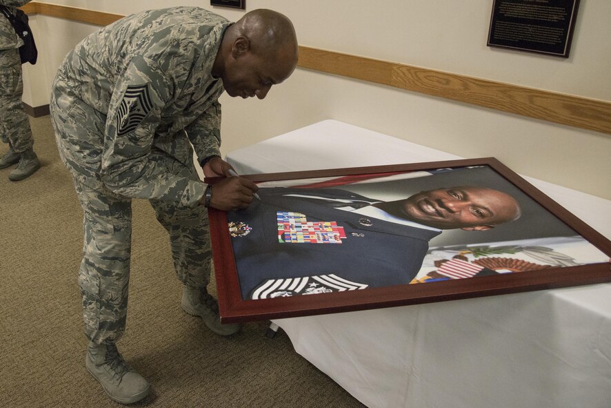 Chief Master Sgt. of the Air Force Kaleth O. Wright signs his official portrait May 3,
2017, inside the Chiefs’ Room at the Pfingston Reception Center at Joint Base San
Antonio-Lackland. Each living Airman who has served as chief master sergeant of
the Air Force has visited JBSA-Lackland to autograph their portraits, which are
displayed in a room dedicated to the Air Force’s highest enlisted leaders.