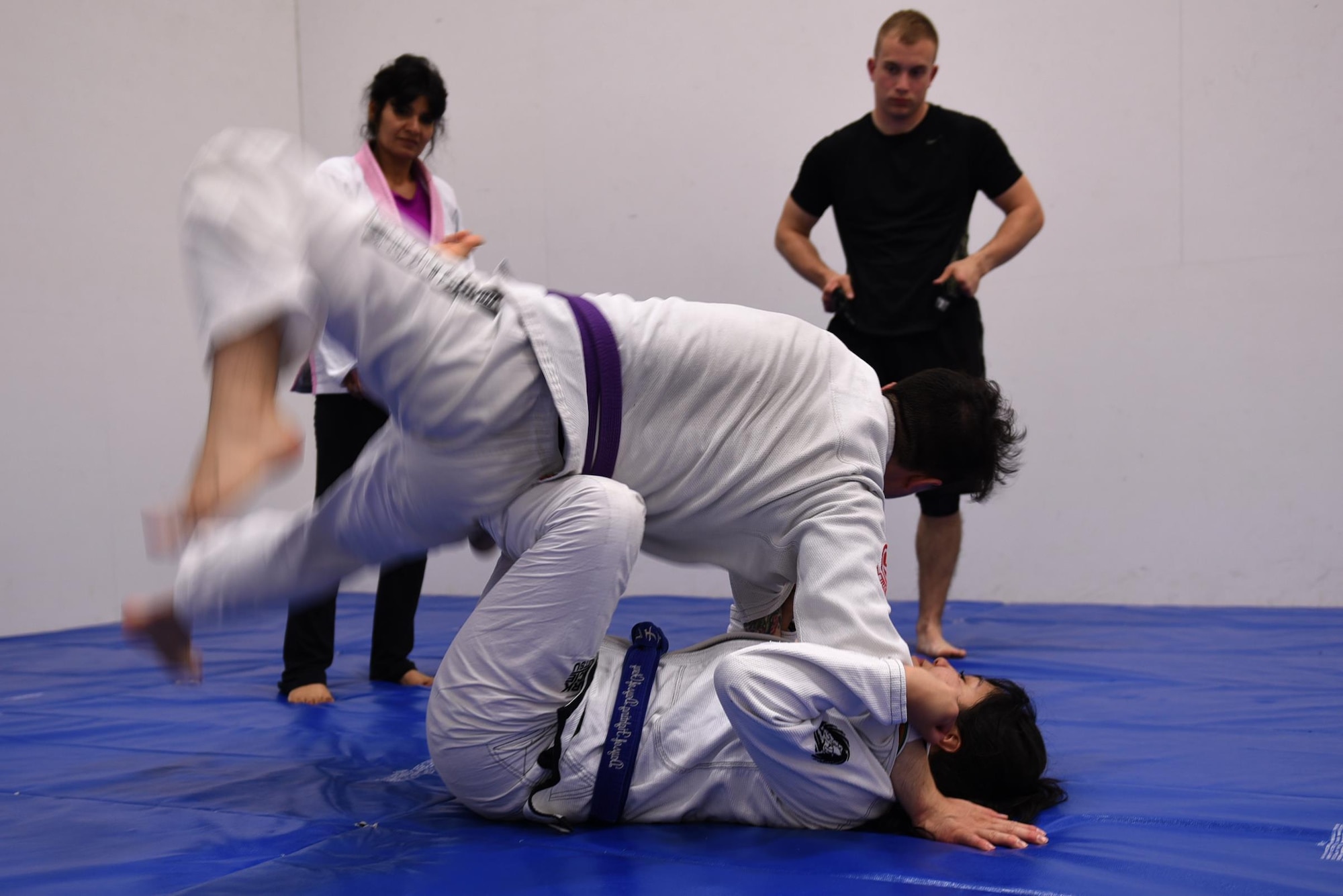 Staff Sgt. Peter Beyer, 19th Civil Engineer Squadron firefighter, and Letia Eclavea, University of Maryland University College student, demonstrate a Brazilian Jiu Jitsu grappling technique April 24, 2017, at the Fitness Center on Little Rock Air Force Base, Ark. Brazilian Jiu Jitsu stimulates the mind, body and spirit while creating social bonds which strengthens the four pillars of Comprehensive Airman Fitness. (U.S. Air Force photo by Airman 1st Class Kevin Sommer Giron)