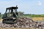 Spc. Jeffrey Nichols of the 381st Engineer Company, 926th Engineer Battalion, 926th Engineer Brigade, United States Army Reserves, bulldozes rock for a road on the Non-Standard Live-Fire Range at Joint National Training Center, Cincu, Romania, as part of Resolute Castle 17. Resolute Castle 17 is an exercise strengthening the NATO alliance and enhancing its capacity for joint training and response to threats within the region.