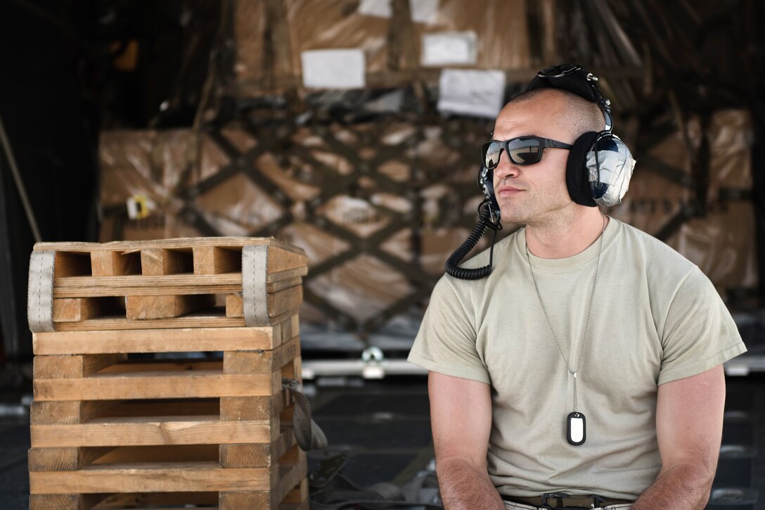 Air Force Senior Airman Brian Aviles takes a break from loading cargo on the ramp of a C-130J Super Hercules aircraft at Bagram Airfield, Afghanistan, May 5, 2017. Aviles is a crew chief assigned to the 455th Expeditionary Aircraft Maintenance Squadron. Air Force photo by Staff Sgt. Benjamin Gonsier