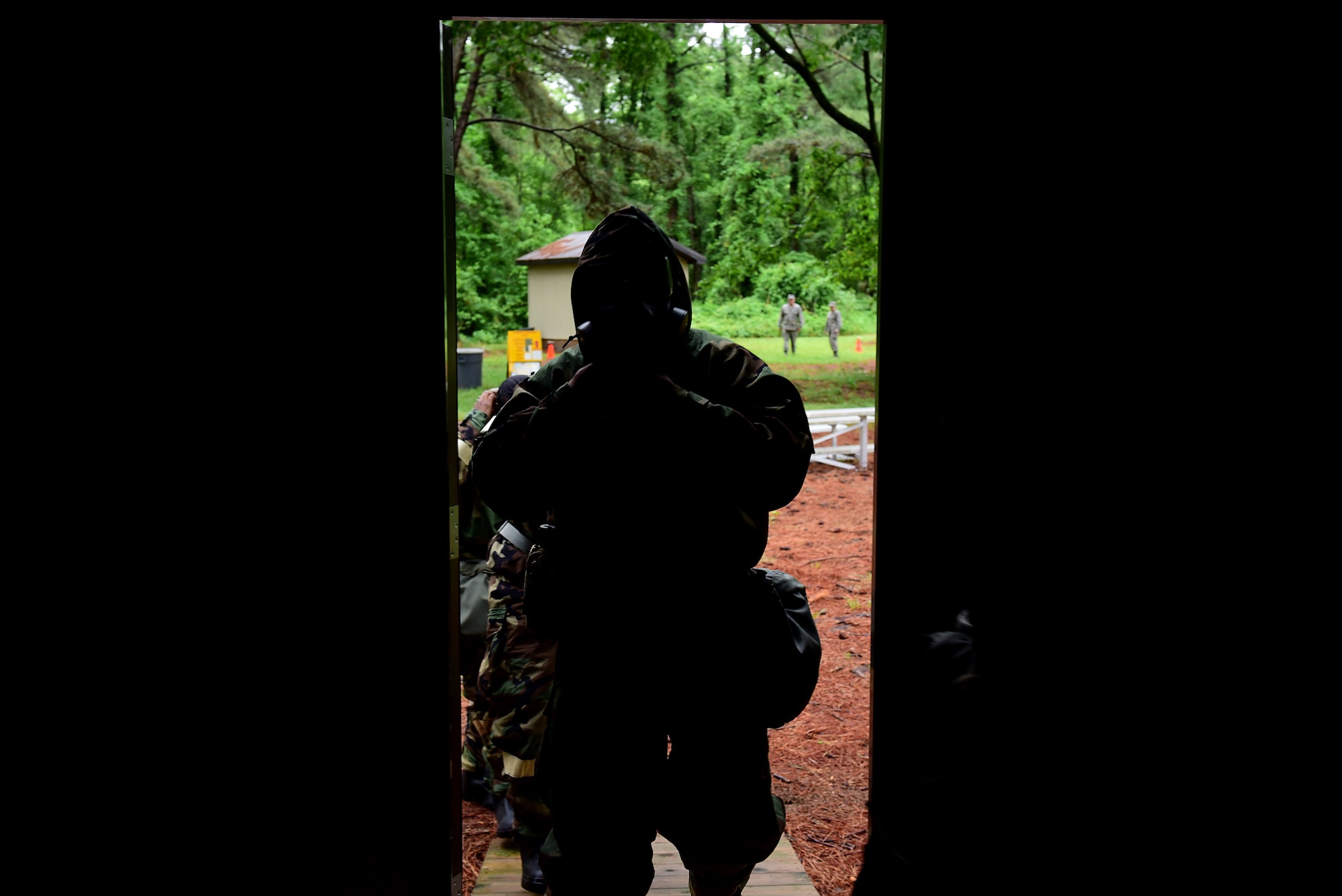 An Airman in mission-oriented protective posture gear walks into a simulated hardened bunker during a chemical, biological, radioactive, and nuclear hands-on course, May 2, 2017, at Seymour Johnson Air Force Base, North Carolina. The Airmen were tested on their ability to correctly don MOPP gear and perform post-attack reconnaissance sweeps. (U.S. Air Force photo by Airman 1st Class Kenneth Boyton)