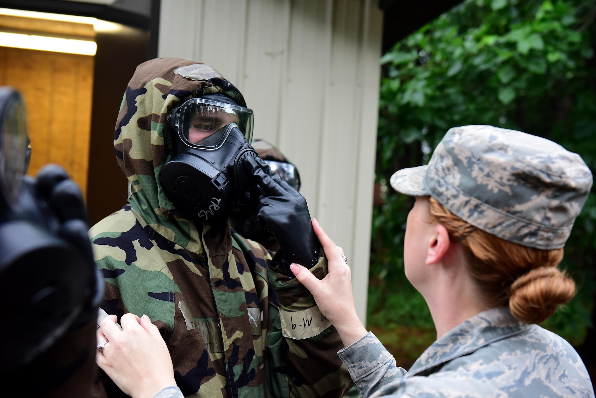 Senior Airman Bonnie Aubin, 4th Civil Engineer Squadron emergency management journeyman (right), checks an Airman for discrepancies in their mission-oriented protective posture gear during a chemical, biological, radioactive, and nuclear hands-on course,  May 2, 2017, at Seymour Johnson Air Force Base, North Carolina. One mistake can create a pathway for a chemical agent to penetrate the gear. (U.S. Air Force photo by Airman 1st Class Kenneth Boyton)