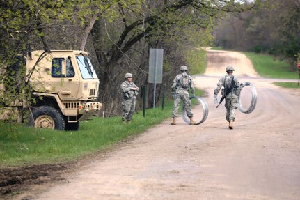 Service members at Fort McCoy for training in the 86th Training Division’s Warrior Exercise 86-17-02 prepare concertina wire for use near Tactical Training Base Justice on North Post during exercise operations May 3, 2017, at Fort McCoy, Wis. Nearly 6,000 Soldiers participated in the Warrior Exercise that focuses on realistic and austere operational environments. The exercise is aimed at testing and developing leaders at every echelon. One of the key objectives for the 2017 Warrior Exercise was to enable units at the platoon level to succeed in a tactical environment when faced with the stressors of combat. (U.S. Army Photo by Scott T. Sturkol, Public Affairs Office, Fort McCoy, Wis.)