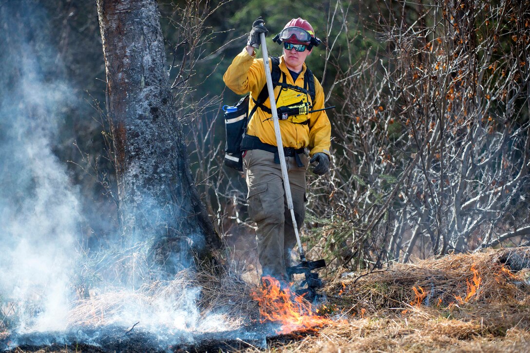 Stephen Spealman observes smoldering landscape during a controlled burn at the Infantry Platoon Battle Course at Joint Base Elmendorf-Richardson, Alaska, May 4, 2017. Spealman is a firefighter assigned to the 673d Civil Engineer Squadron. Air Force photo by Alejandro Pena