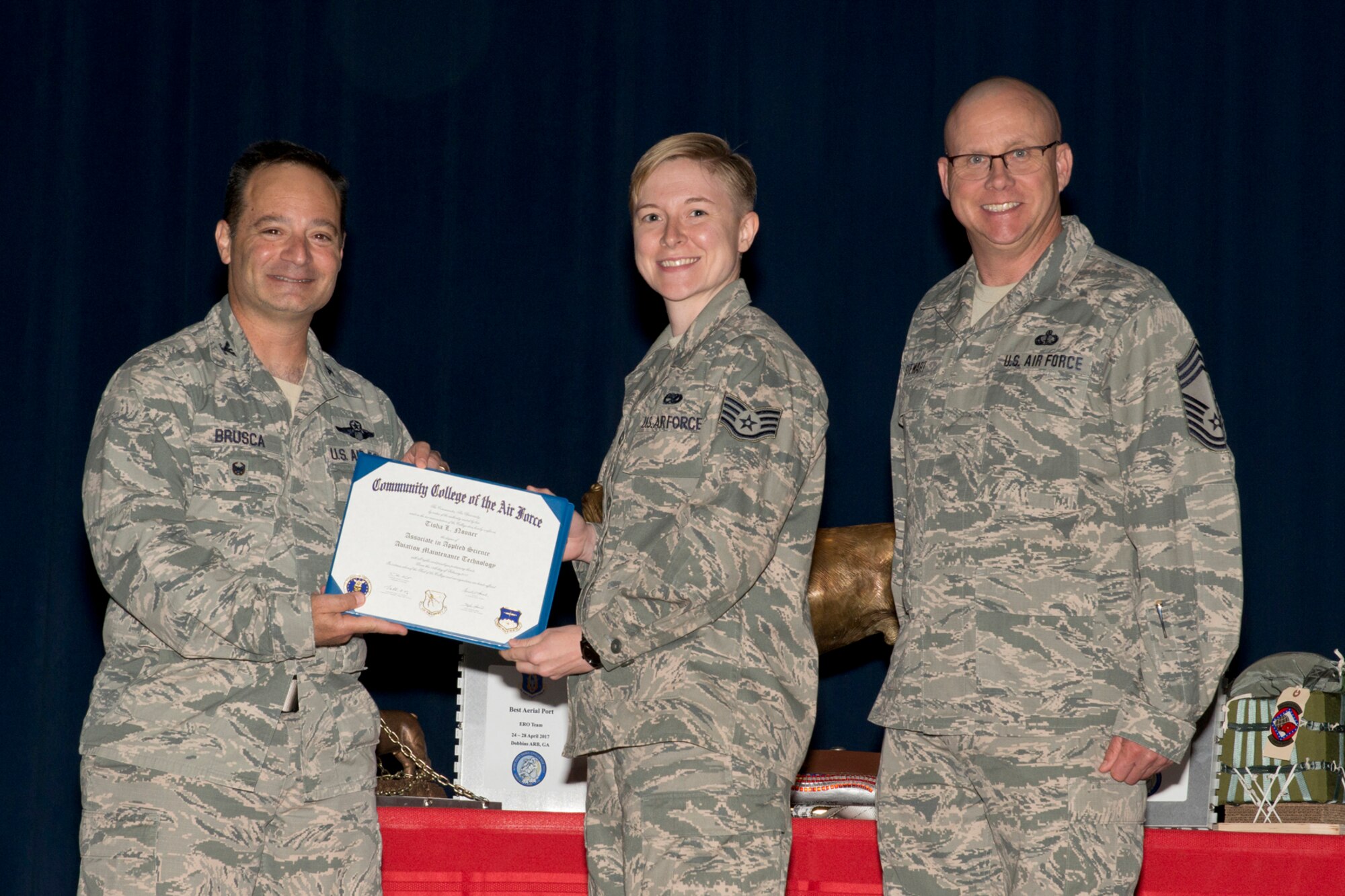 U.S. Air Force Reserve Col. Anthony Brusca, interim commander for the 913th Airlift Group, Staff Sgt. Tisha L. Nooner, aircraft electrical and environmental systems journeyman, 913th Maintenance Squadron and Chief Master Sgt. Paul Stewart, superintendent, 913 AG, pose for a photo during Commander’s Call May 7, 2017, at Little Rock Air Force Base, Ark. Nooner received her Community College of the Air Force Associate degree in Applied Science Aviation Maintenance Technology. (U.S. Air Force photo by Master Sgt. Jeff Walston/Released)