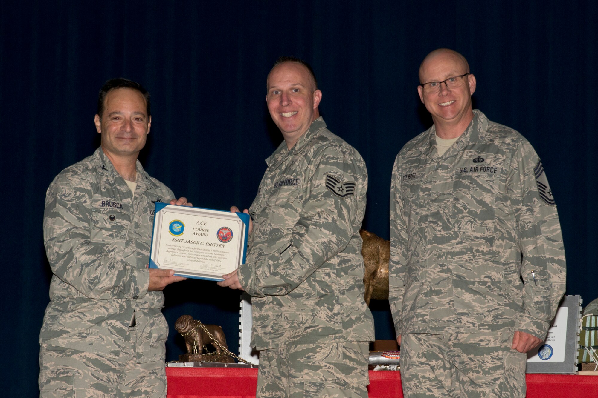 U.S. Air Force Reserve Col. Anthony Brusca, interim commander for the 913th Airlift Group, Staff Sgt. Jason Britten, aerospace ground equipment apprentice, 913th Maintenance Squadron and Chief Master Sgt. Paul Stewart, superintendent, 913 AG, pose for a photo during Commander’s Call May 7, 2017, at Little Rock Air Force Base, Ark. Britten was recognized for receiving the ACE Award March 20, 2017, while at Sheppard AFB, Texas. The ACE award is earned by maintaining a perfect 100 percent on all tests and evaluations through an entire course. (U.S. Air Force photo by Master Sgt. Jeff Walston/Released)