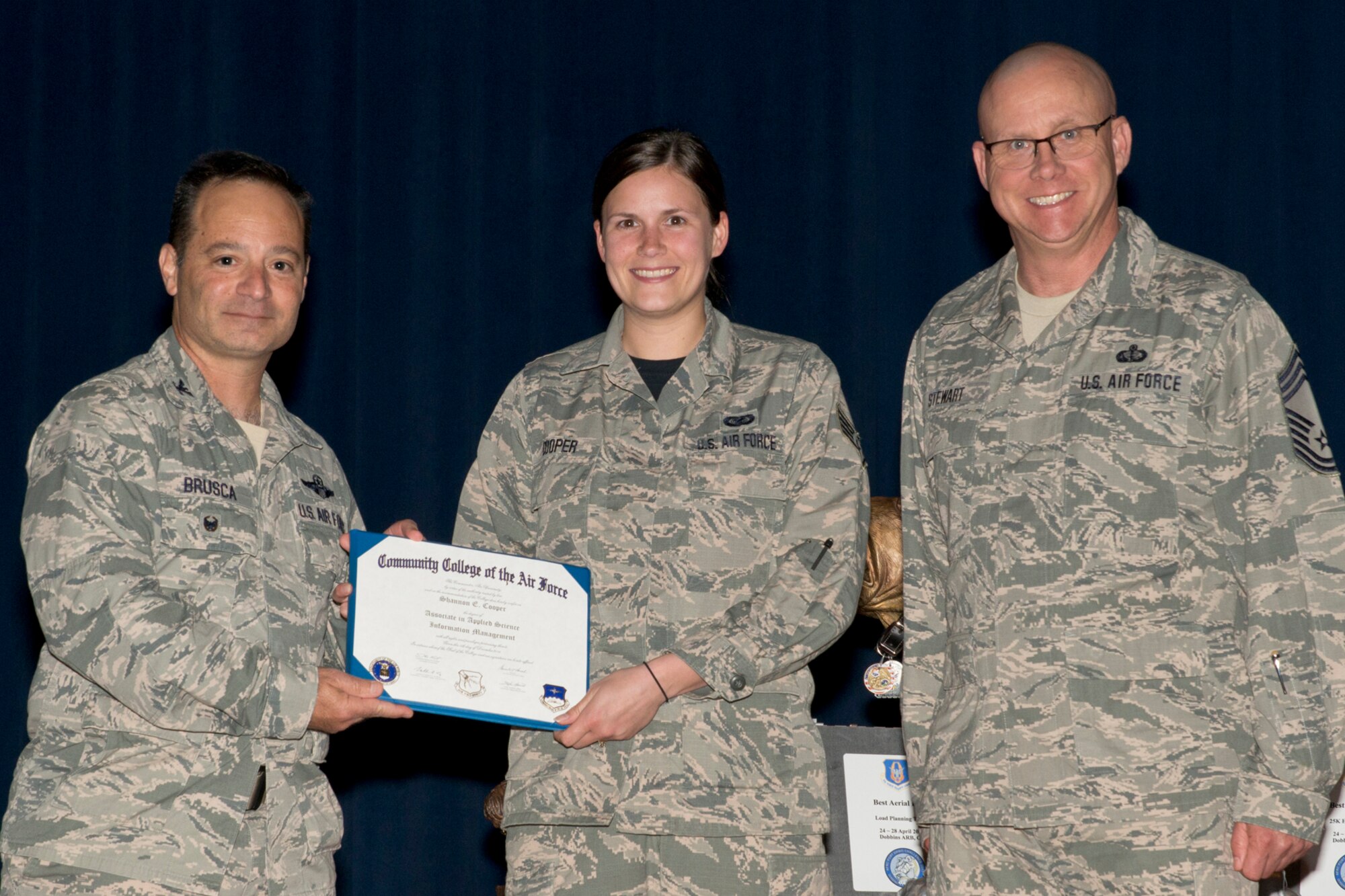 U.S. Air Force Reserve Col. Anthony Brusca, interim commander for the 913th Airlift Group, Staff Sgt. Shannon E. Cooper, administration journeyman, 913th Operations Support Squadron, and Chief Master Sgt. Paul Stewart, superintendent, 913 AG, pose for a photo during Commander’s Call May 7, 2017, at Little Rock Air Force Base, Ark. Cooper received her Community College of the Air Force Associate degree in Applied Science Information Management. (U.S. Air Force photo by Master Sgt. Jeff Walston/Released)