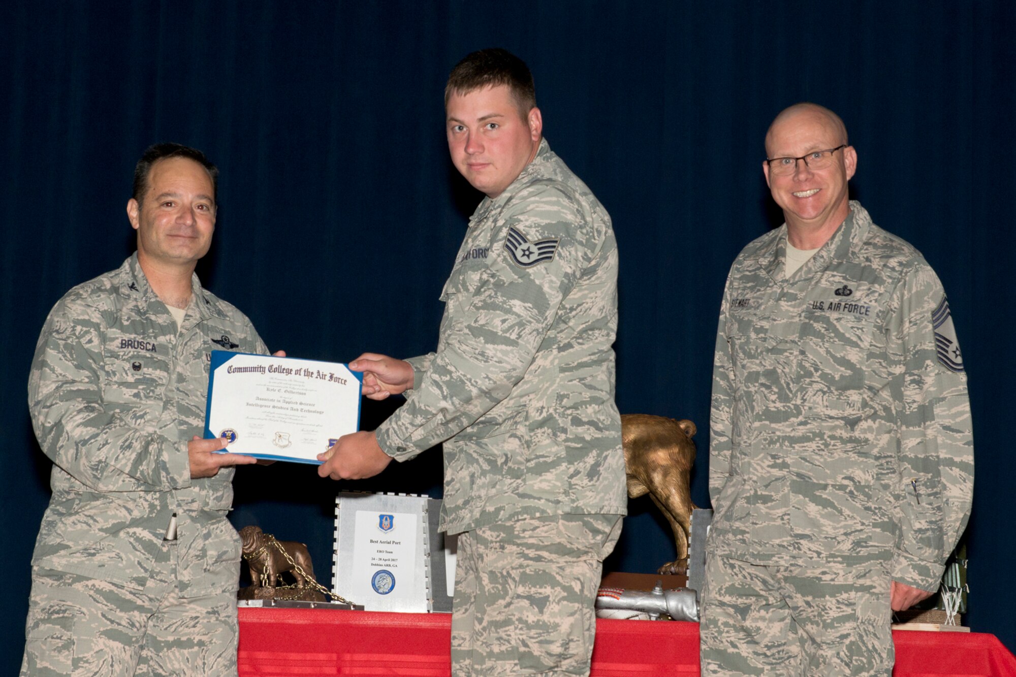 U.S. Air Force Reserve Col. Anthony Brusca, interim commander for the 913th Airlift Group, Staff Sgt. Kyle E. Gilbertson, intelligence analyst, 913th Operations Support Squadron and Chief Master Sgt. Paul Stewart, superintendent, 913 AG, pose for a photo during Commander’s Call May 7, 2017, at Little Rock Air Force Base, Ark. Gilbertson received his Community College of the Air Force Associate degree in Applied Science Intelligence Studies and Technology. (U.S. Air Force photo by Master Sgt. Jeff Walston/Released)