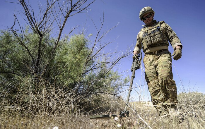 Tech. Sgt. Christopher Townsend, 99th Civil Engineer Squadron explosive ordinance technician, uses a metal detector to search for a simulated improvised explosive device during a training exercise on Nellis Air Force Base, Nev., May 3, 2017. EOD technicians conduct long-range and close in reconnaissance, identify and assesses ordnance condition and advise commanders on recommended safe withdrawal distances. (U.S. Air Force photo by Senior Airman Kevin Tanenbaum/Released)