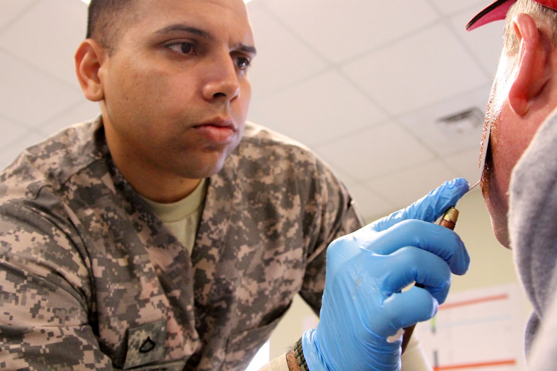 MUSCATATUCK URBAN TRAINING CENTER, Indiana – Pfc. Jose Sanchez from Cardina, Puerto Rico, an ammunition specialist with the U.S. Army Reserve’s 266th Ordnance Company, Aguadilla, Puerto Rico, applies a fake wound onto a civilian volunteer at the Muscatatuck Urban Training Center (MUTC), Indiana, May 6, 2017. Nearly 4,100 Soldiers from across the country are participating in Guardian Response 17, a multi-component training exercise to validate U.S. Army units’ ability to support the Defense Support of Civil Authorities (DSCA) in the event of a Chemical, Biological, Radiological, and Nuclear (CBRN) catastrophe.