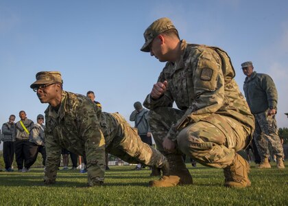 U.S. Army Reserve Sgt. 1st Class Timothy Onderko (kneeling), of Lawton, Okla., watches a Soldier demonstrate the proper form for push-ups for members of the 335th Signal Command (Theater) before an Army Physical Fitness Test in East Point, Ga., May 6, 2017. The APFT is designed to test the muscular strength, endurance, and cardiovascular respiratory fitness of soldiers in the Army. Soldiers are scored based on their performance in three events consisting of the push-up, sit-up, and a two-mile run, ranging from 0 to 100 points in each event. (U.S. Army Reserve photo by Staff Sgt. Ken Scar)