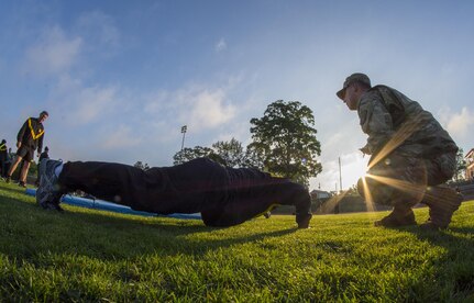 U.S. Army Reserve Sgt. 1st Class Timothy Onderko, of Lawton, Okla., grades Sgt. 1st Class Brent Powell, of Pocahontas, Ark., as Powell does push-ups to pass the Army Physical Fitness Test on a field at Woodward Academy in East Point, Ga., May 6, 2017. The APFT is designed to test the muscular strength, endurance, and cardiovascular respiratory fitness of soldiers in the Army. Soldiers are scored based on their performance in three events consisting of the push-up, sit-up, and a two-mile run, ranging from 0 to 100 points in each event. (U.S. Army Reserve photo by Staff Sgt. Ken Scar)