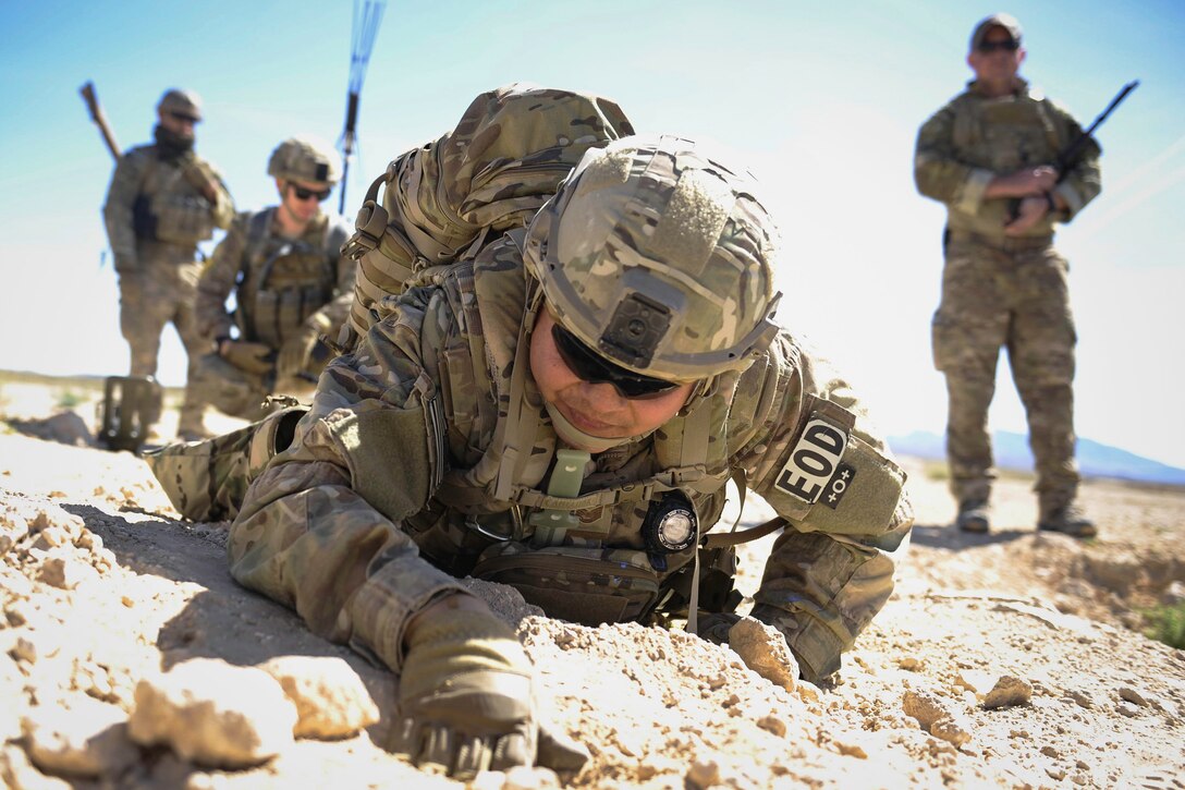 Air Force Tech. Sgt. Kenneth Westrum, an explosive ordnance disposal technician, searches for a detonation wire during a training exercise at Nellis Air Force Base, Nev., May 3, 2017. Air Force photo by Senior Airman Kevin Tanenbaum