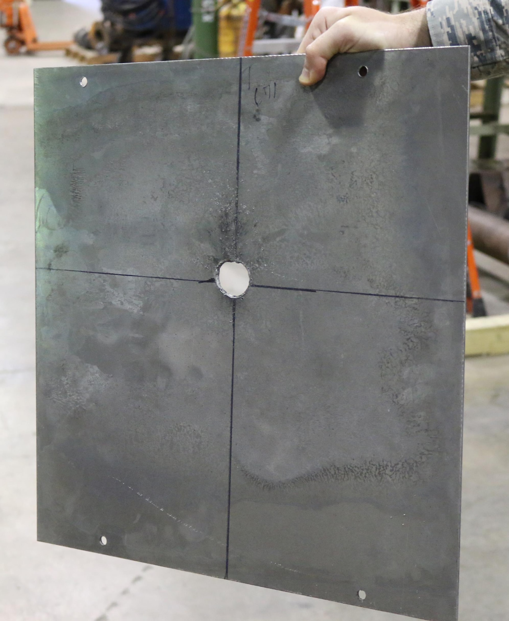 This metal witness plate was struck by a hypervelocity projectile during a recent checkout of the AEDC Range S-1. S-1 is currently undergoing checkout operations in preparation for three upcoming test projects. Several successful test launches, like the one above, have recently been performed in S-1. (U.S. Air Force photo/Deidre Ortiz) 