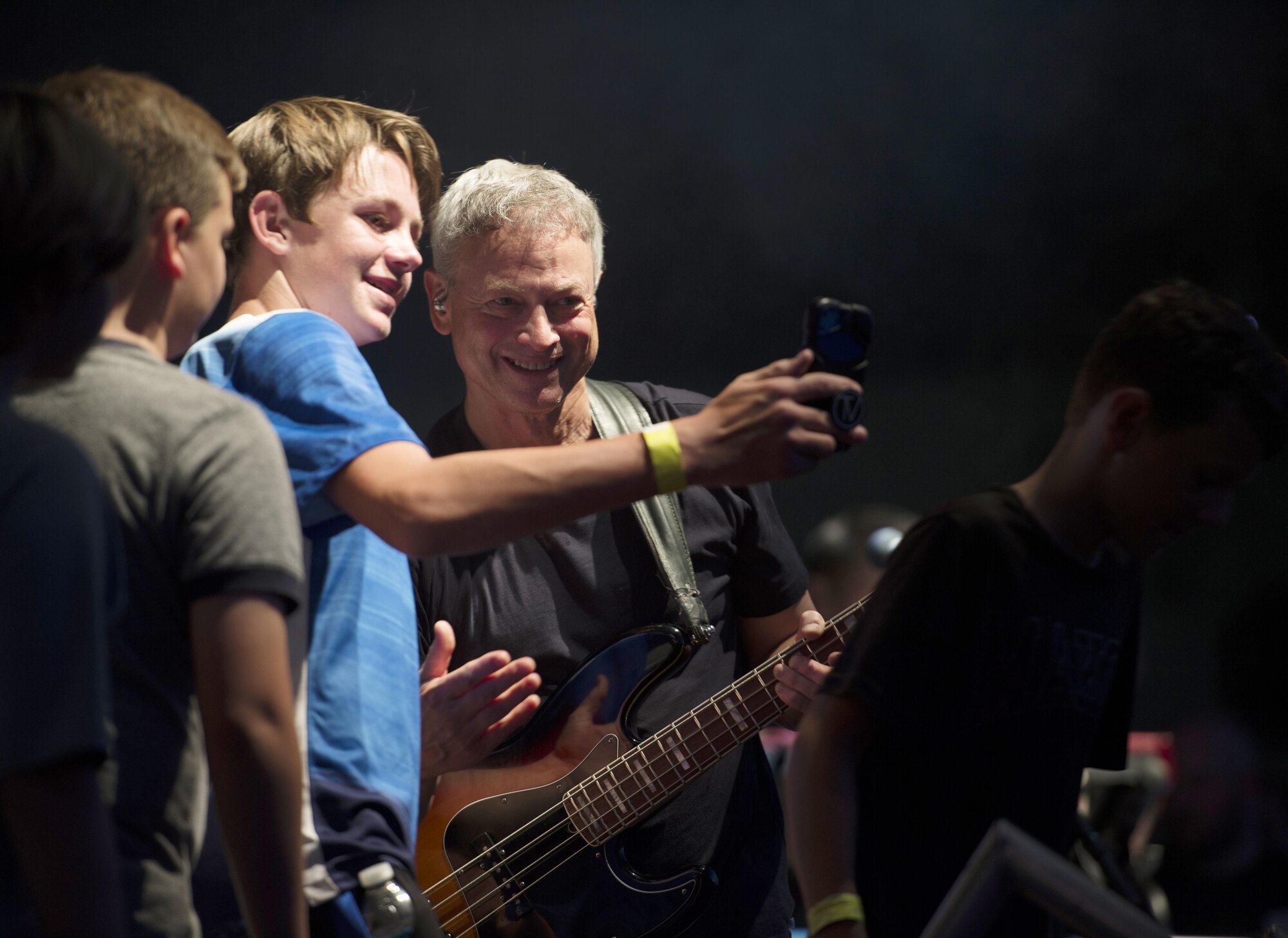 Gary Sinise, bassist for the Lt. Dan Band, takes a photo with MacDill youth during a performance at MacDill Air Force Base, Fla., April 29, 2017. This performance marked the first time the Lt. Dan Band has visited MacDill. (U.S. Air Force photo by Airman 1st Class Adam R. Shanks)