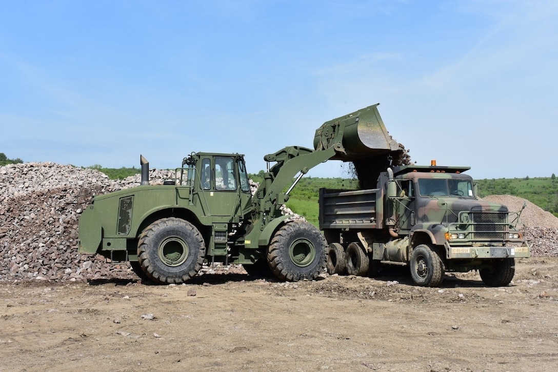 A front-end loader loads road rock into the back of a M-917 20-ton dump truck at Joint National Training Center, Cincu, Romania, as a part of Resolute Castle 17. Resolute Castle 17 is an exercise strengthening the NATO alliance and enhancing its capacity for joint training and response to threats within the region.