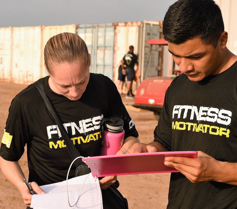 Navy Petty Officer 1st Class Celeste Dunlap, left, Combined Joint Task Force Horn of Africa’s command fitness leader, reviews scores with an assistant command fitness leader at Camp Lemonnier, Djibouti, April 28, 2017. Air Force photo by Tech. Sgt. Andria Allmond