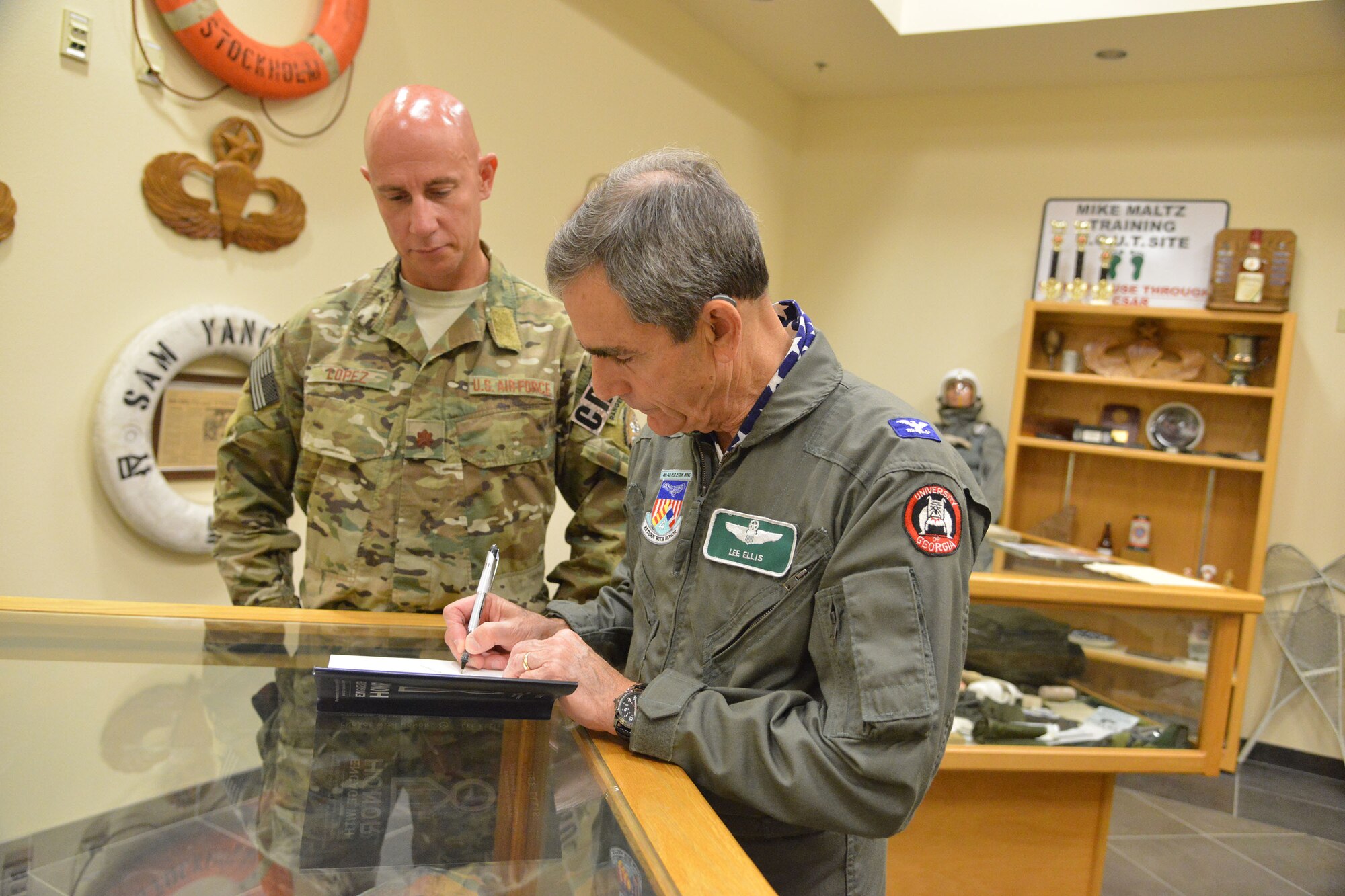 Retired colonel and former Vietnam prisoner of war Lee Ellis autographs his book for Maj. Joseph Lopez, 351st Battlefield Airman Training Squadron commander. Ellis was at Kirtland May 2-3 to speak to the base about the importance of character, courage, commitment in leaders.