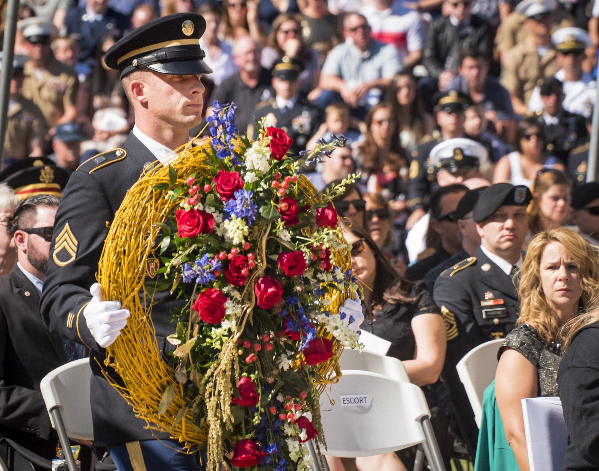 An Army staff sergeant carries in a wreath to be placed in front of the monument at the 48th Annual Explosive Ordnance Disposal Memorial Service at the Kauffman EOD Training Complex at Eglin Air Force Base, Fla., May 6. Names of recent fallen and past EOD technicians are added to the memorial wall during a ceremony each year. The Army and Navy added six new names this year. The all-service total now stands at 326. (U.S. Air Force photo/ Samuel King Jr.)