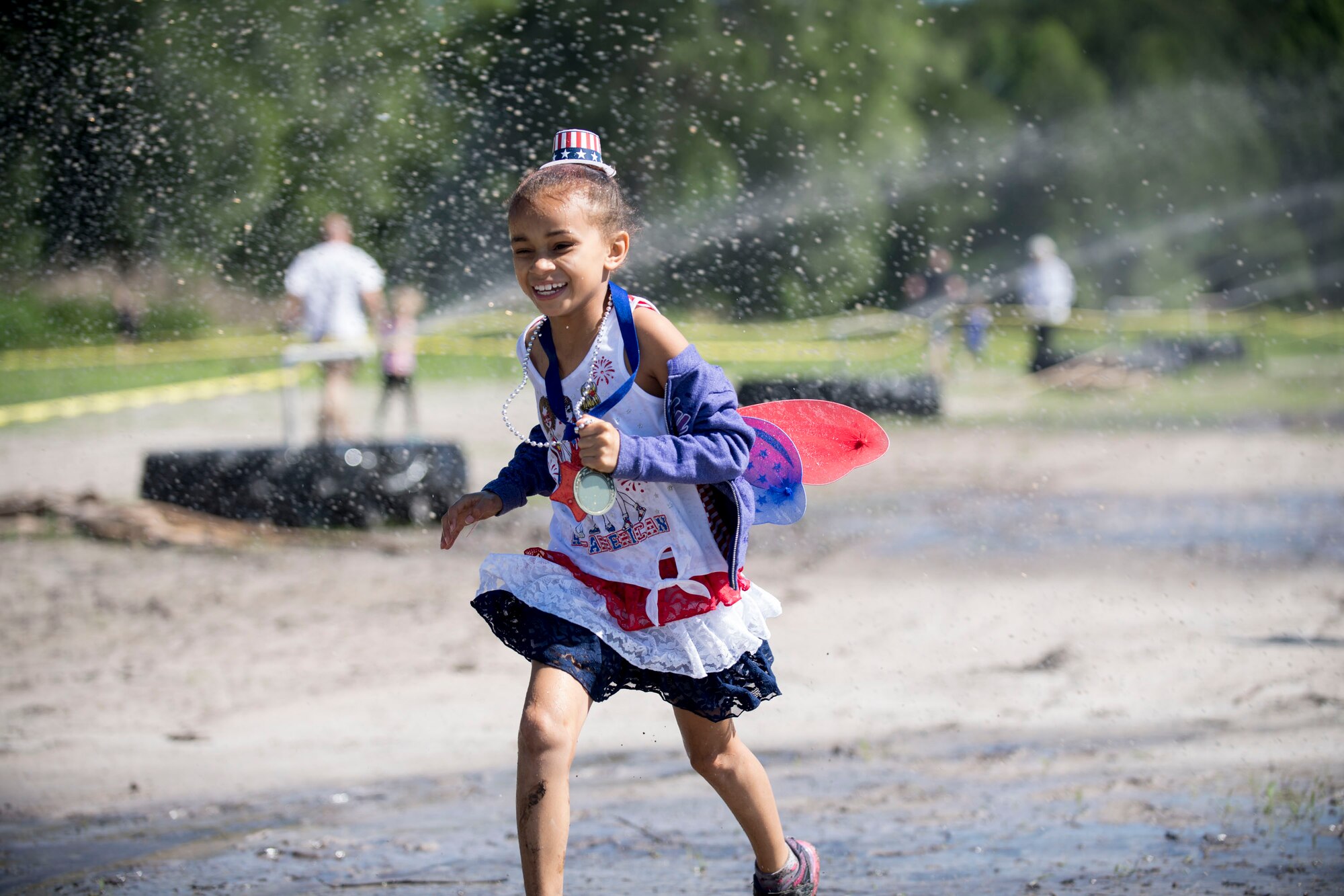 A child participant runs through water during the annual Moody Mud Run, May 6, 2017, in Ray City, Ga. The Fourth Annual Moody Mud consisted of both adult and child course that challenged more than 600 participants with obstacles over 4.2 miles. (U.S. Air Force photo by Airman 1st Class Daniel Snider)