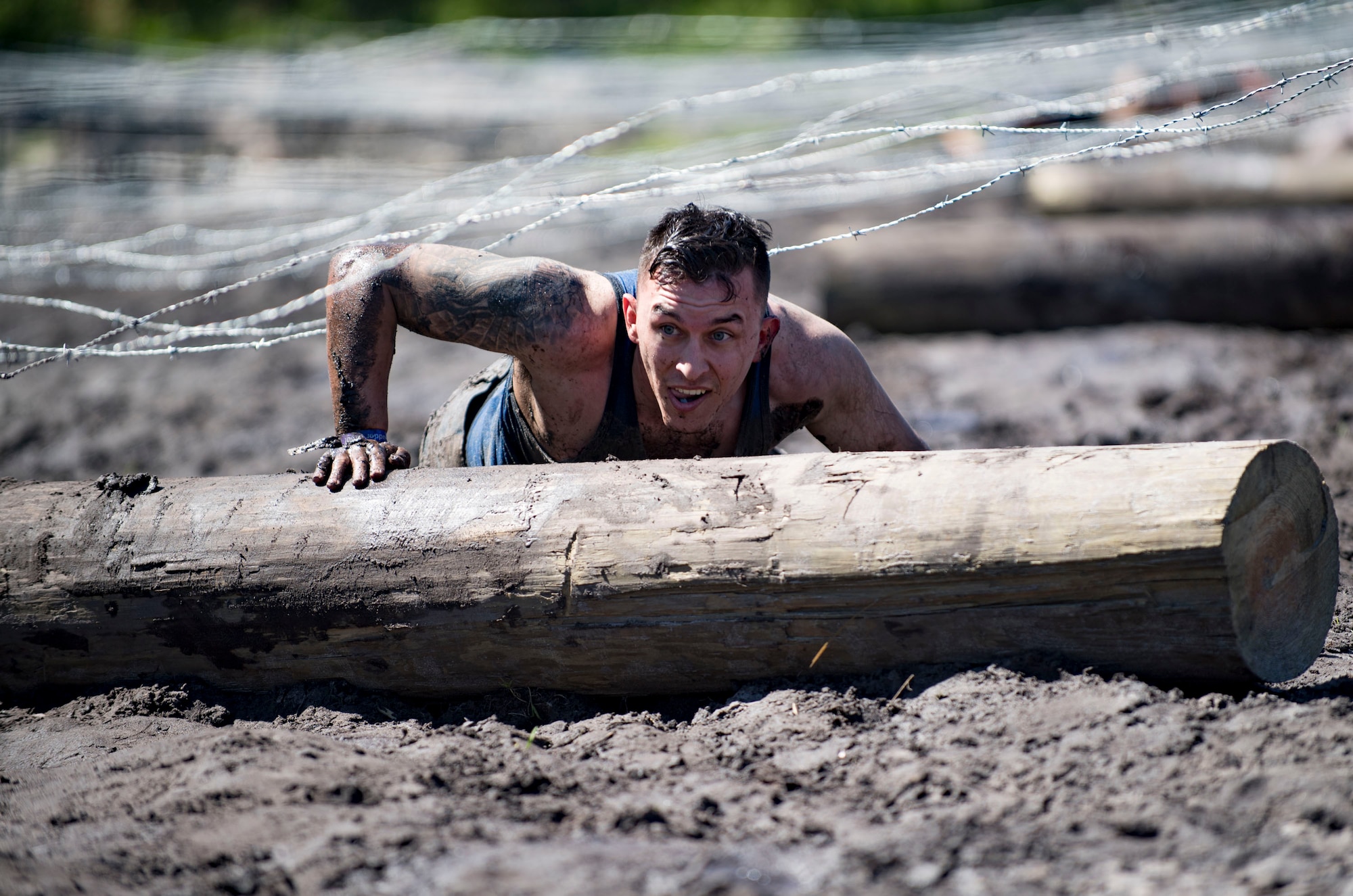 A participant low-crawls over a log during the annual Moody Mud Run, May 6, 2017, in Ray City, Ga. The Fourth Annual Moody Mud consisted of both adult and child course that challenged more than 600 participants with obstacles over 4.2 miles. (U.S. Air Force photo by Airman 1st Class Daniel Snider)