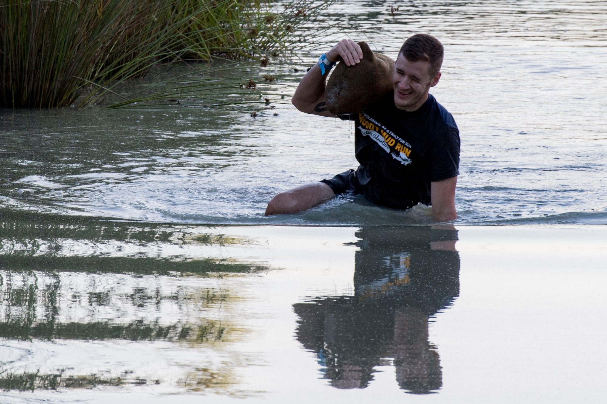 A Moody Mud Run participant carries a sandbag through several feet of water, May 6, 2017, in Ray City, Ga. The Fourth Annual Moody Mud consisted of both adult and child course that challenged more than 600 participants with obstacles over 4.2 miles. (U.S. Air Force photo by Staff Sgt. Eric Summers Jr.)