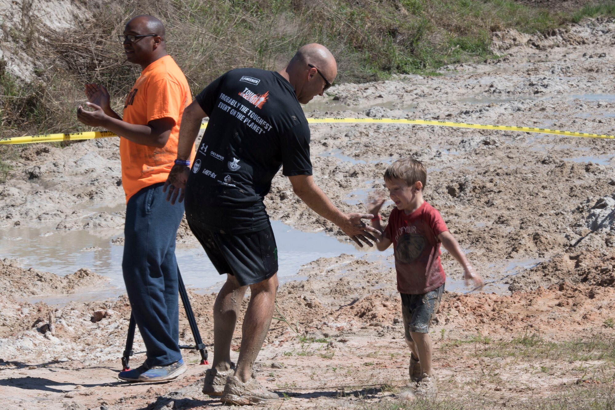 A son high-fives his father after completing the last obstacle of the Moody Mud Run children’s course, May 6, 2017, in Ray City, Ga. The Fourth Annual Moody Mud consisted of both adult and child course that challenged more than 600 participants with obstacles over 4.2 miles. (U.S. Air Force photo by Staff Sgt. Eric Summers Jr.)