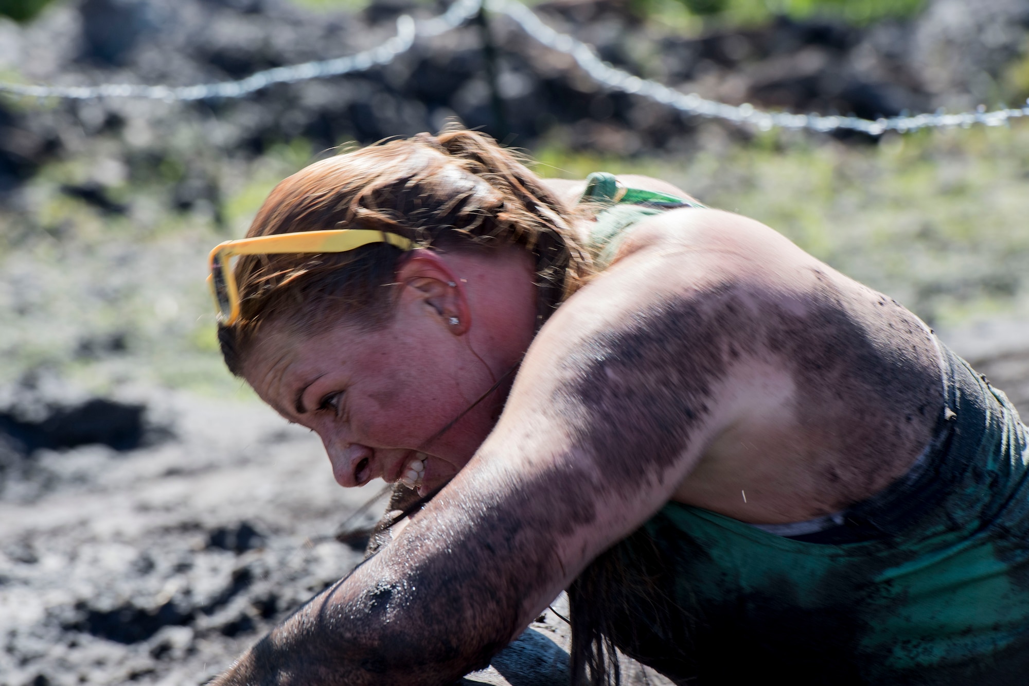 A Moody Mud Run participant pulls herself between a log and barbed wire, May 6, 2017, in Ray City, Ga. The Fourth Annual Moody Mud consisted of both adult and child course that challenged more than 600 participants with obstacles over 4.2 miles. (U.S. Air Force photo by Staff Sgt. Eric Summers Jr.)