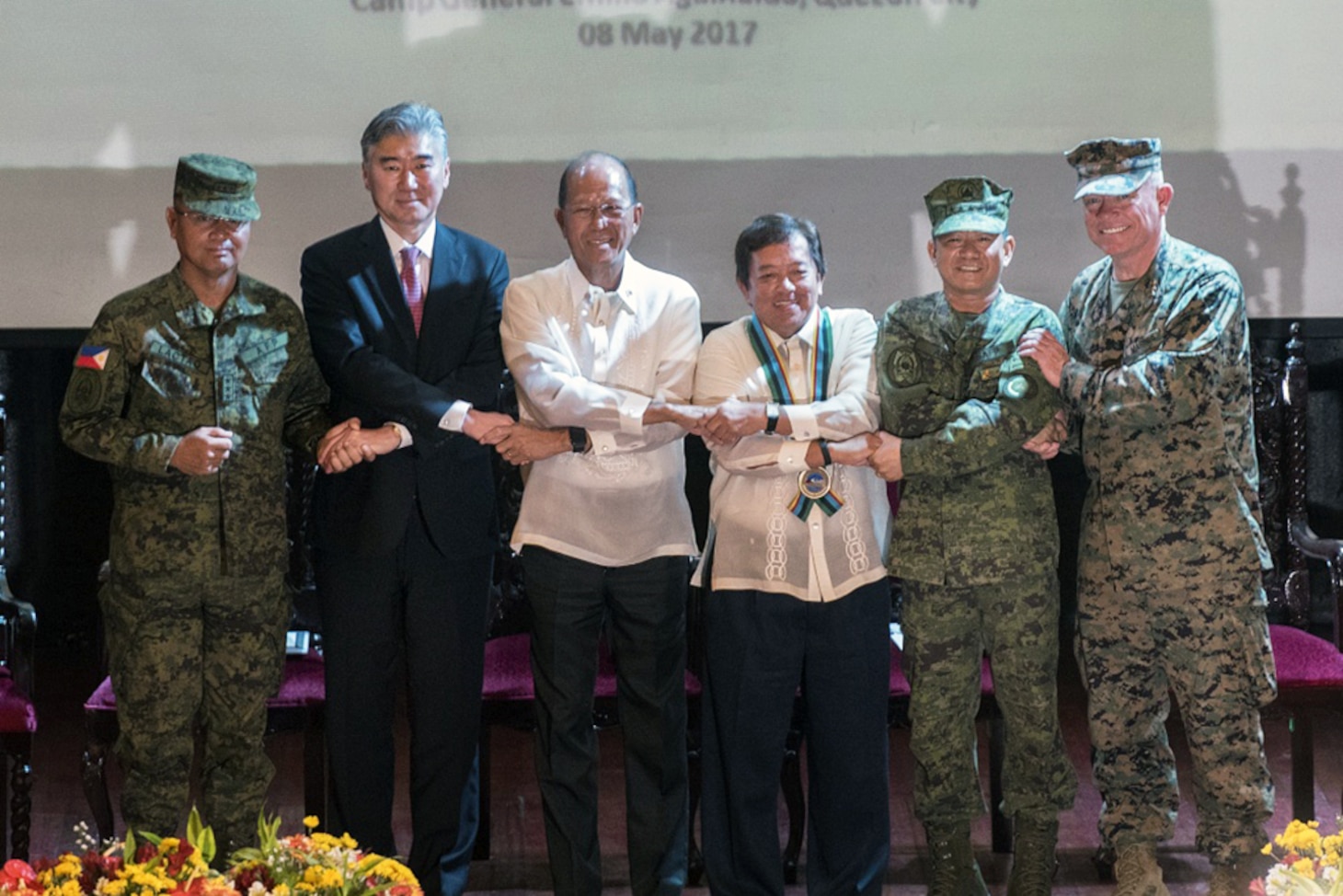 Armed Forces of the Philippines Lt. Gen. Oscar T. Lacto, left, The Honorable Ambassador Sung Y. Kim, Secretary Delfin N. Lorenzana, Under Secretary Ariel y. Abadilla, AFP Gen. Edruardo M. Año, and U.S. Marine Lt. Gen. Lawrence D. Nicholson stand “shoulder-to-shoulder” and shake hands during the opening ceremony for Balikatan 2017 at Camp Aguinaldo, Quezon City, May 8, 2017. Lacto is the Philippine exercise director for Balikatan. Kim is the U.S. Ambassador to the Philippines. Lorenzana is the Philippine Secretary of National Defense. Abadilla is the Philippine Undersecretary for Civilian Security and Consular Concerns. Año is the Chief of Staff of the AFP. Nicholson is the commanding general of III Marine Expeditionary Force. Balikatan is an annual U.S.-Philippine bilateral military exercise focused on a variety of missions including humanitarian and disaster relief, counterterrorism, and other combined military operations.