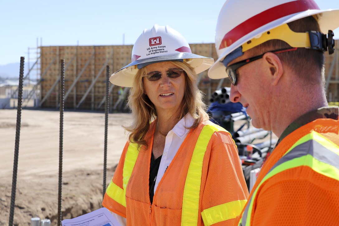 Construction Representative Michele Mickle (left), U.S. Army Corps of Engineers Los Angeles District's Tucson Resident Office, briefs District Commander Col. Kirk Gibbs, as he tours the future home of the Air Force Reserve's 306th Rescue Squadron Guardian Angel facility March 8. Guardian Angel is a human based weapon system comprised of Combat Rescue Officers, Pararescuemen, Survival, Evasion, Resistance, Escape Specialists, and uniquely trained support personnel. The project's horseshoe design was done by Louisville District's in-house designers using best practice guidance from the squadron.     